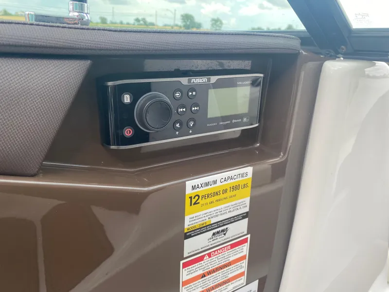 Slide: The Image of 2018 Monterey 224FS boat dashboard with Fusion stereo and capacity warning label. - 13