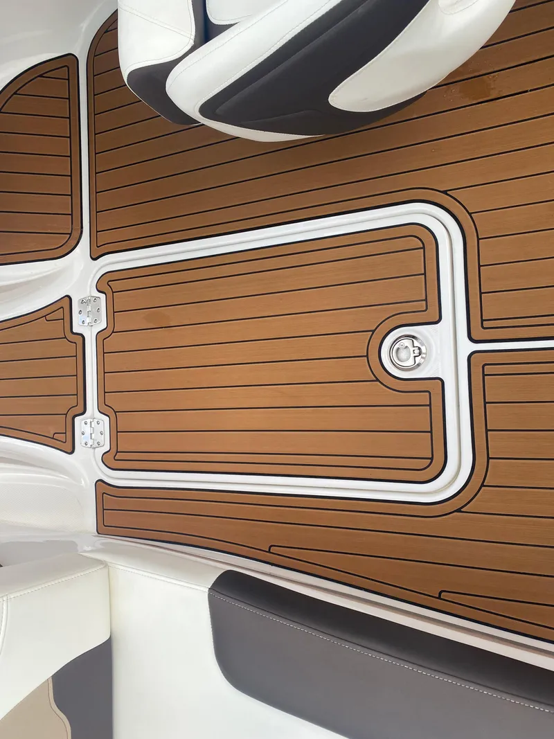 Slide: The Image of 2018 Monterey 224FS boat interior with teak-style flooring and cushioned seating. - 20