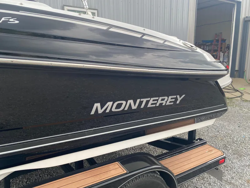 Slide: The Image of 2018 Monterey 224FS boat on trailer, black exterior, parked near a metal building. - 6