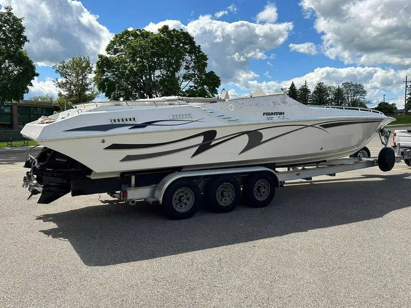 Slide: The Image of 1994 Fountain 35 Lightning speedboat on trailer, parked outdoors under a partly cloudy sky. - 4