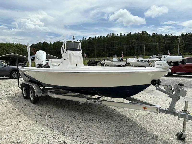 Slide: The Image of 2026 Blazer PureBay 2200 boat on trailer, parked outdoors under cloudy sky. - 2