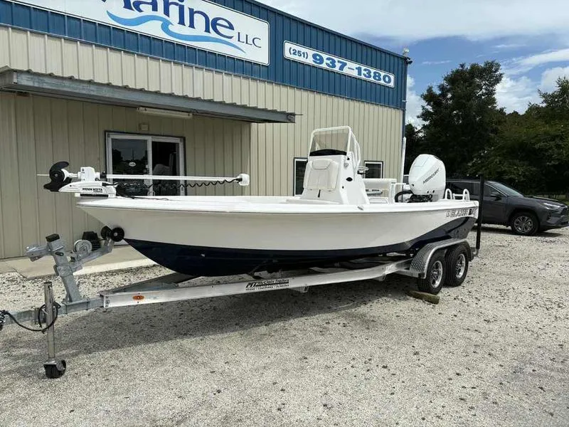 Slide: The Image of 2026 Blazer PureBay 2200 boat on trailer outside marine dealership. - 4