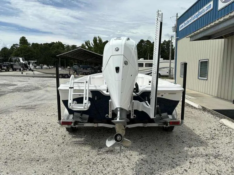 Slide: The Image of 2026 Blazer PureBay 2200 boat on trailer, rear view, parked outside dealership. - 5