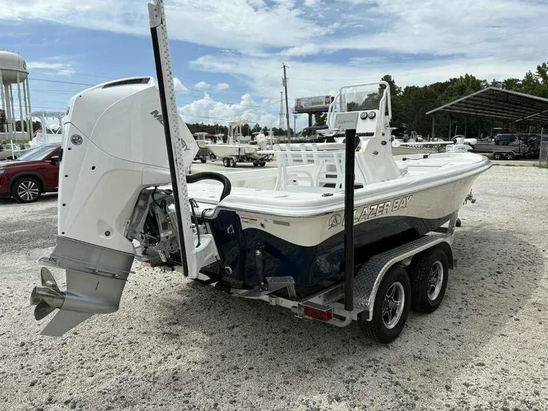 Slide: The Image of 2026 Blazer PureBay 2200 boat on trailer, outdoor dealership setting. - 6