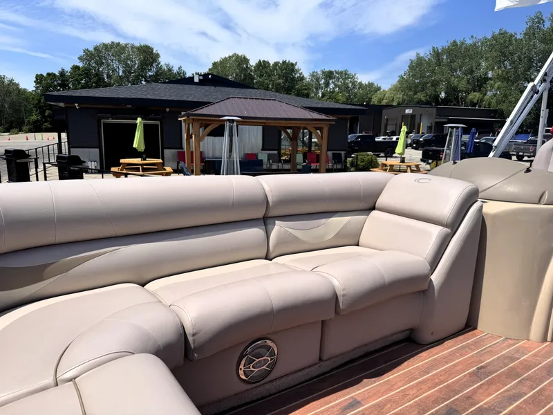 Slide: The Image of 2013 Crest Classic 230SLR pontoon boat with beige seating, docked near a modern building. - 17