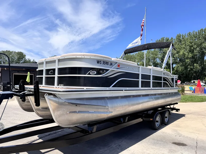 Slide: The Image of 2013 Crest Classic 230SLR pontoon boat on trailer, under clear blue sky. - 2
