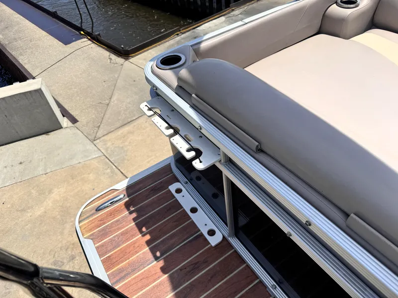 Slide: The Image of 2013 Crest Classic 230SLR boat with cushioned seating and wooden deck near water. - 21