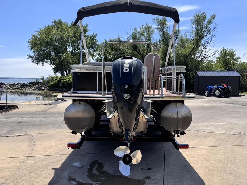 Slide: The Image of 2013 Crest Classic 230SLR pontoon boat with 150 horsepower engine at a lakeside dock. - 3