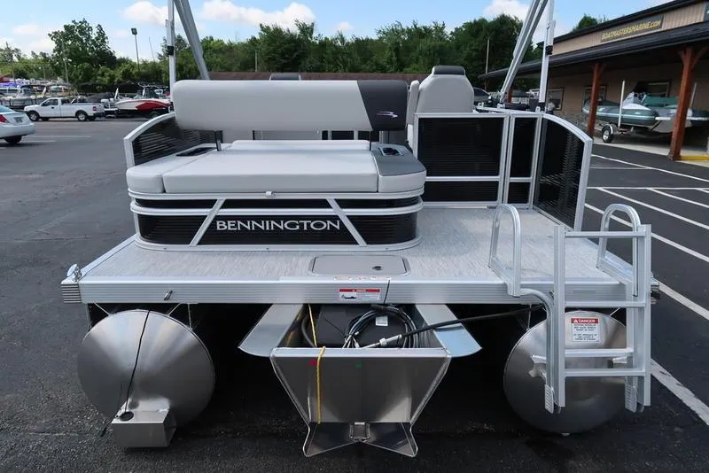Slide: The Image of 2026 Bennington S Swingback 22 SSB pontoon boat, rear view, in a parking lot. - 11