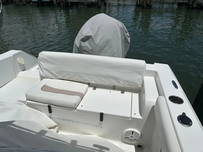 Slide: The Image of 2013 Sea Hunt Edge 24 boat interior with white seating and covered motor. - 12