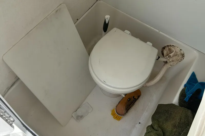 Slide: The Image of Boat bathroom with toilet and cleaning supplies on a 2013 Sea Hunt Edge 24. - 14