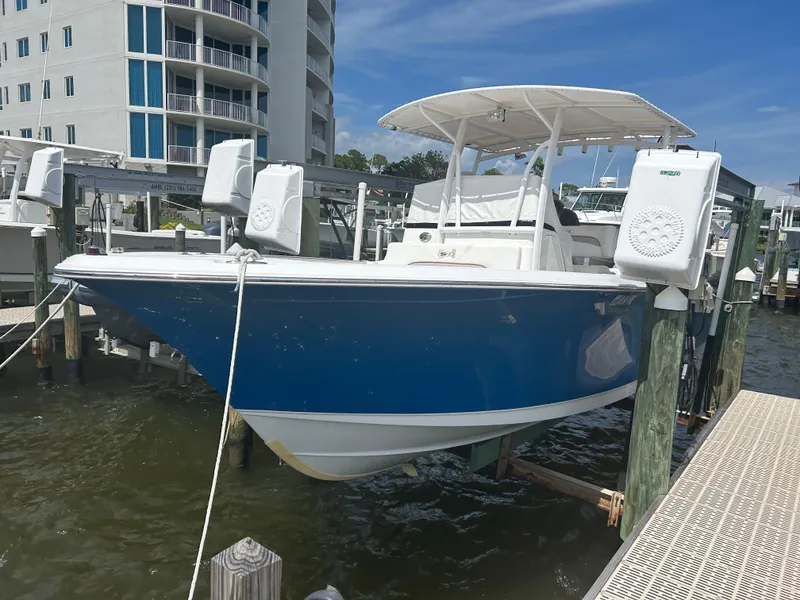 Slide: The Image of 2013 Sea Hunt Edge 24 boat docked near waterfront building. - 2
