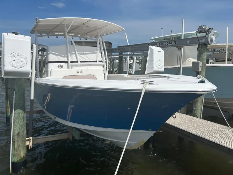 Slide: The Image of 2013 Sea Hunt Edge 24 boat docked on a lift under a clear blue sky. - 3