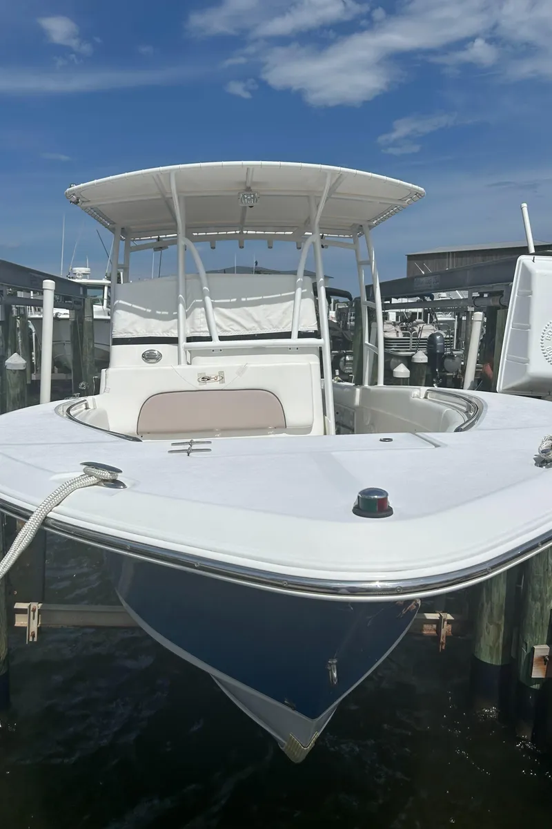Slide: The Image of 2013 Sea Hunt Edge 24 boat docked at marina under clear blue sky. - 4