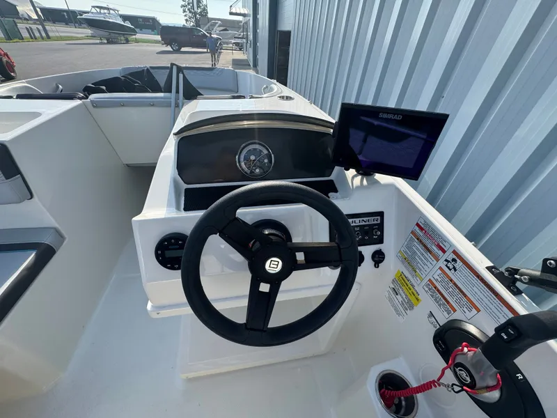 Slide: The Image of 2022 Bayliner Element M17 boat dashboard with steering wheel and navigation display. - 14