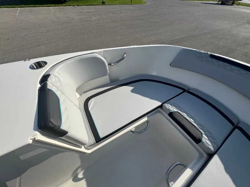 Slide: The Image of 2022 Bayliner Element M17 boat interior with cushioned seating and cup holder. - 2