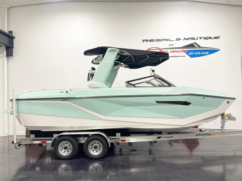 The Image of 2025 Nautique Super Air Nautique G23 boat on trailer in showroom. - 1