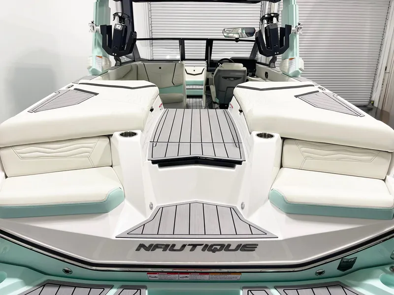 Slide: The Image of 2025 Nautique Super Air Nautique G23 boat interior with white and mint green seating. - 7
