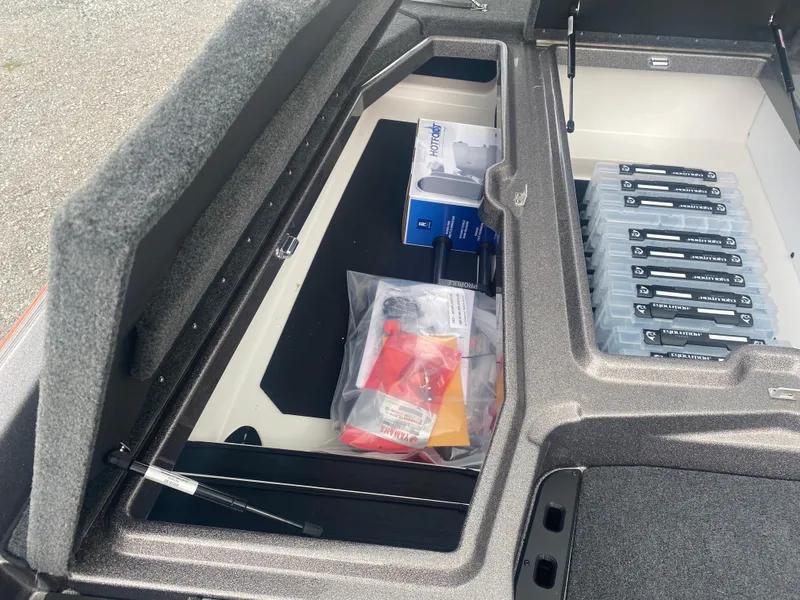 Slide: The Image of Open storage compartment in 2026 Skeeter ZXE 21 boat, showing organized gear and accessories. - 17