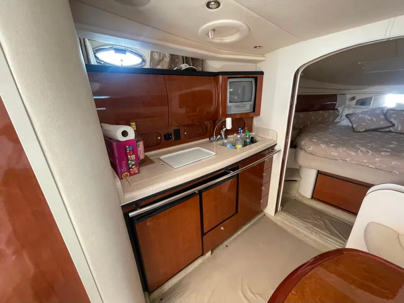 Slide: The Image of 2003 Sea Ray 360 Sundancer interior with kitchenette and cozy sleeping area. - 16