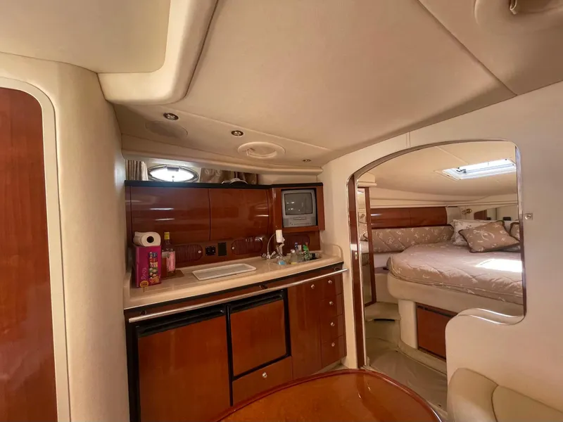 Slide: The Image of 2003 Sea Ray 360 Sundancer interior with kitchenette and cozy sleeping area. - 19