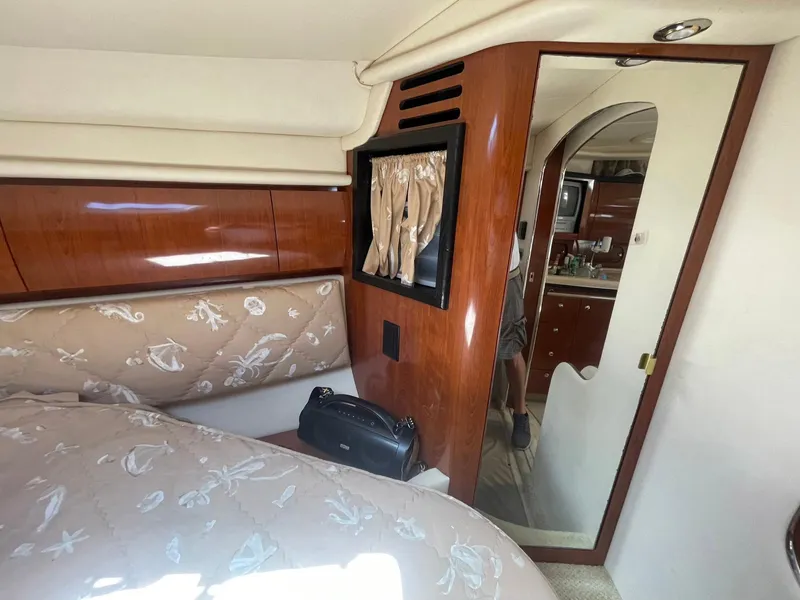 Slide: The Image of Interior of 2003 Sea Ray 360 Sundancer yacht with elegant wood paneling and cozy bedding. - 22