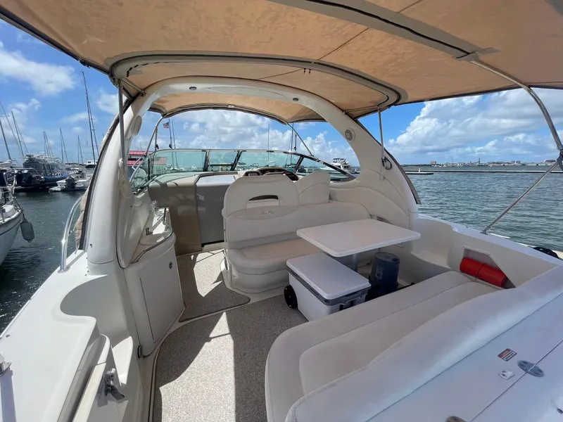 Slide: The Image of 2003 Sea Ray 360 Sundancer yacht interior with seating and table, docked at marina. - 6