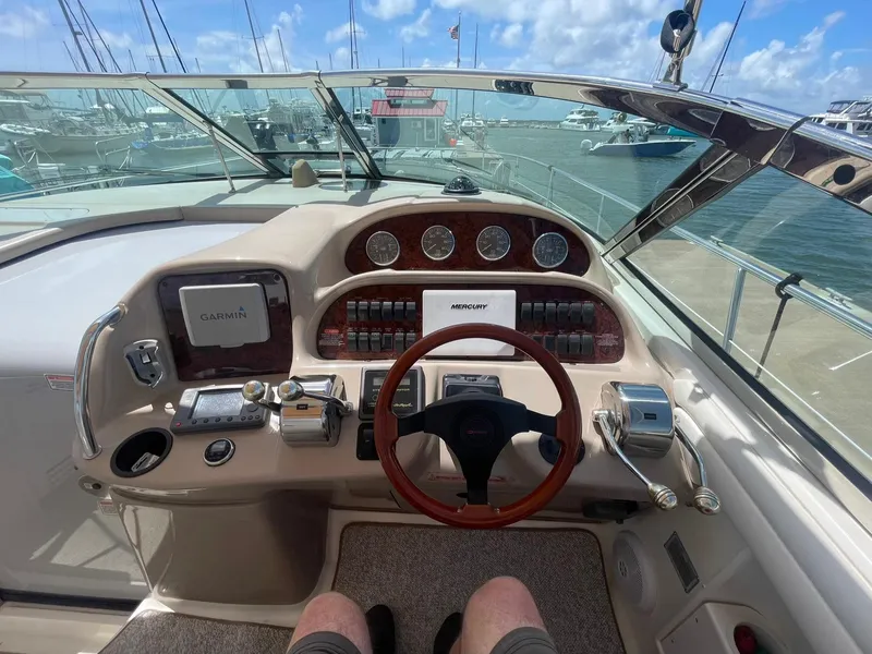 Slide: The Image of 2003 Sea Ray 360 Sundancer helm with Garmin navigation, docked at marina under blue sky. - 9