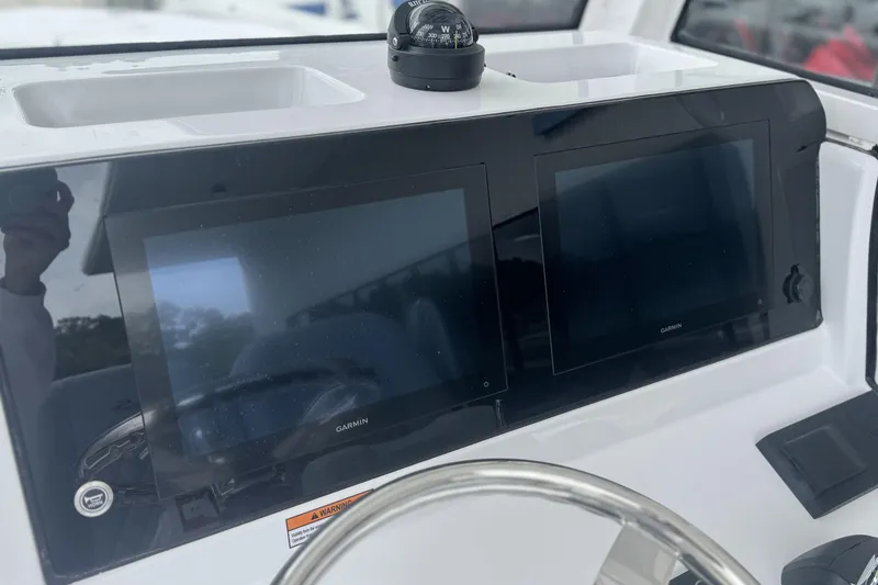 Slide: The Image of 2026 Sportsman Open 232 Center Console dashboard with dual Garmin displays and compass. - 18