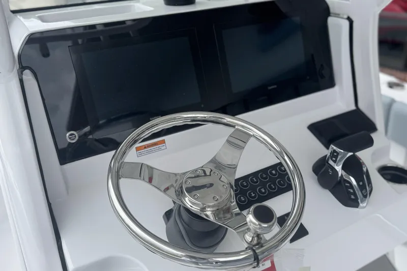 Slide: The Image of 2026 Sportsman Open 232 Center Console helm with dual screens and stainless steel steering wheel. - 19