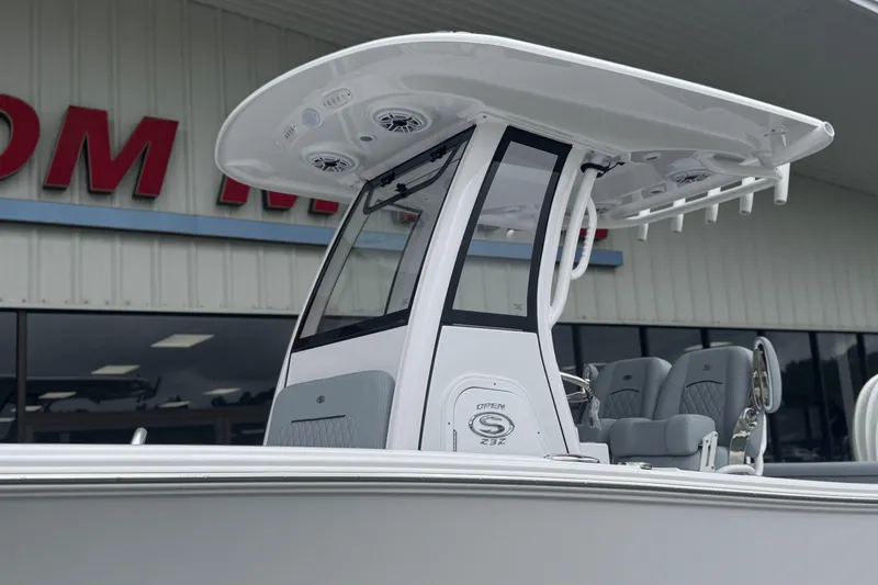 Slide: The Image of 2026 Sportsman Open 232 Center Console boat with T-top and seating, displayed outdoors. - 2