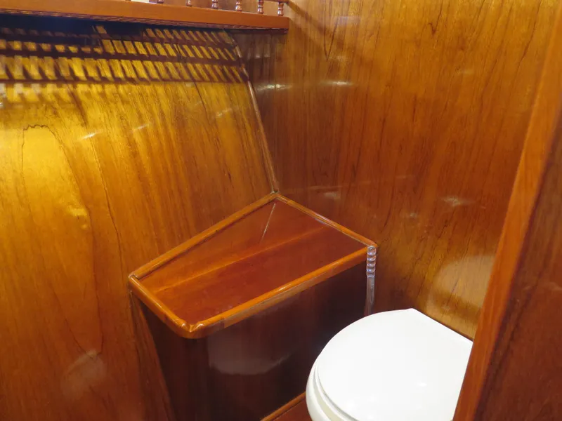 Slide: The Image of Wood-paneled bathroom in 1985 CHB Flush Deck Aftcabin yacht, featuring a white toilet. - 14