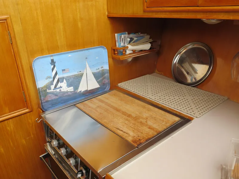 Slide: The Image of 1985 CHB Flush Deck Aftcabin kitchen with stove, cutting board, and nautical decor. - 16