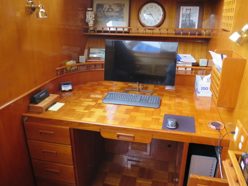 Slide: The Image of 1985 CHB Flush Deck Aftcabin interior with wooden desk, computer, and nautical decor. - 17