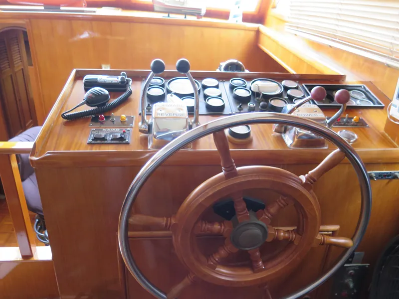 Slide: The Image of 1985 CHB Flush Deck Aftcabin helm with wooden wheel and control panel. - 18