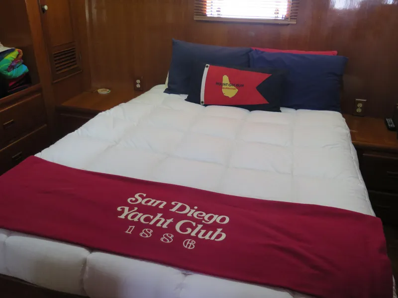 Slide: The Image of Cozy yacht cabin with white bedding, San Diego Yacht Club blanket, and nautical-themed pillow. - 24