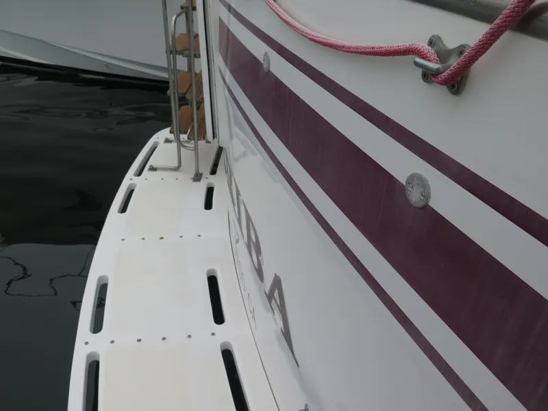 Slide: The Image of 1985 CHB Flush Deck Aftcabin boat with maroon stripes and swim platform. - 3