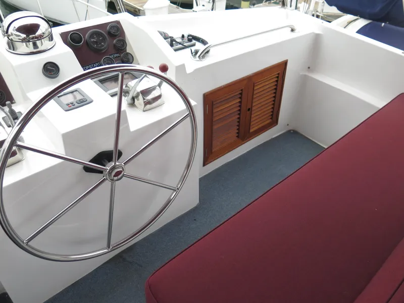 Slide: The Image of 1985 CHB Flush Deck Aftcabin boat helm with steering wheel and control panel. - 5