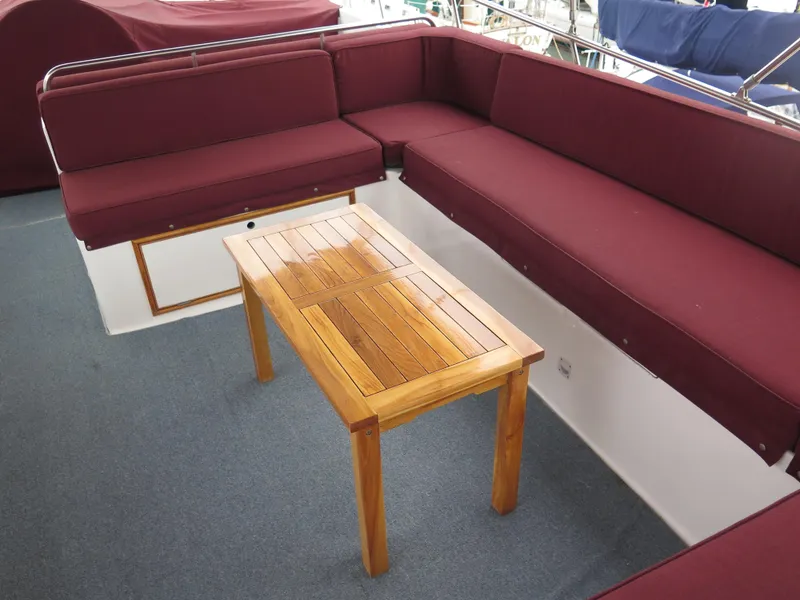 Slide: The Image of 1985 CHB Flush Deck Aftcabin with maroon seating and wooden table on deck. - 6