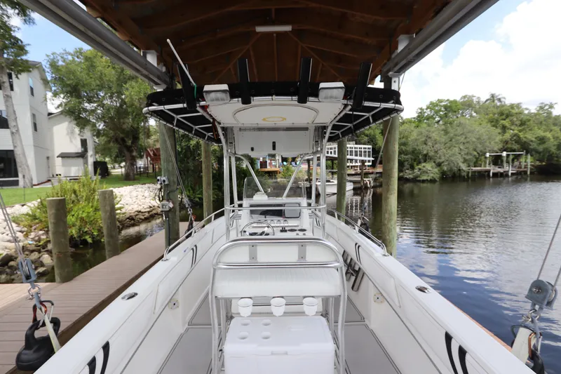 Slide: The Image of 2001 Fountain 25CC boat docked by a scenic riverside with lush greenery. - 10