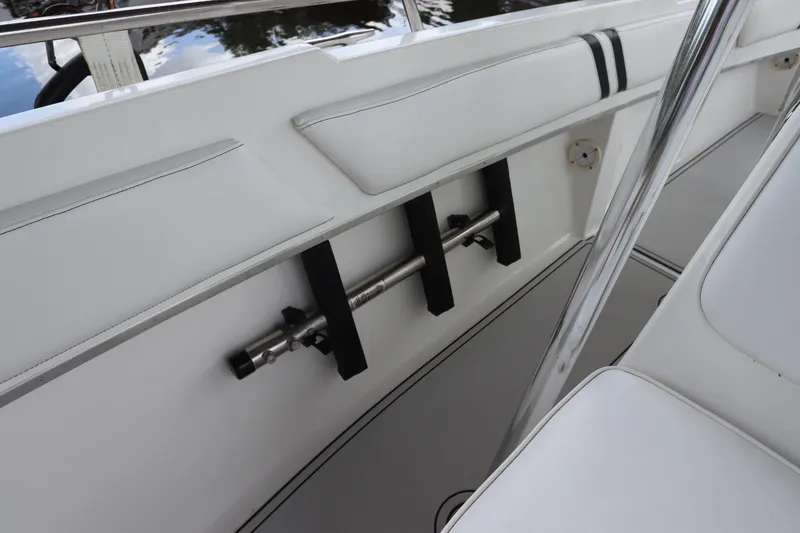 Slide: The Image of Interior of a 2001 Fountain 25CC boat, featuring white seating and rod holders. - 19