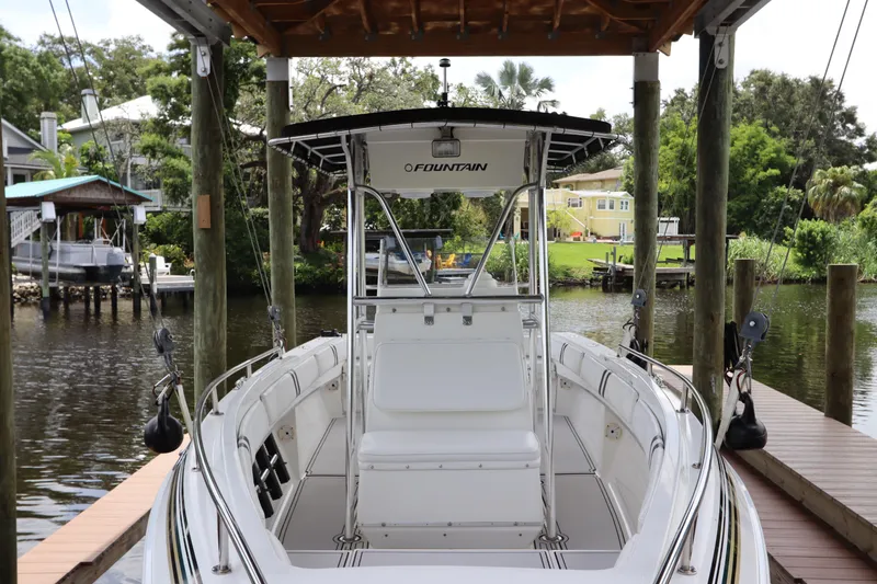 Slide: The Image of 2001 Fountain 25CC boat docked in a scenic riverside setting. - 3