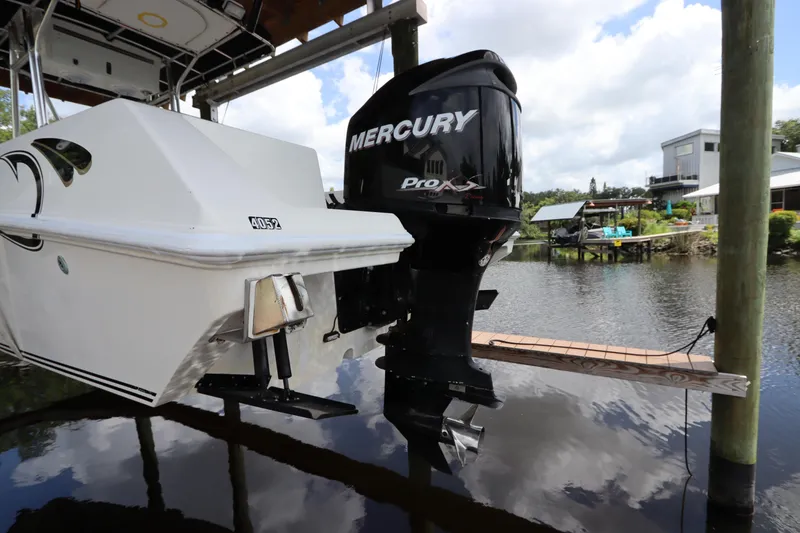 Slide: The Image of 2001 Fountain 25CC boat with Mercury Pro XS outboard motor on a lift by the water. - 5