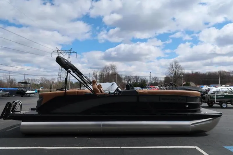 Slide: The Image of 2025 Bennington M Quad Bench 24 MFB pontoon boat under cloudy sky. - 10