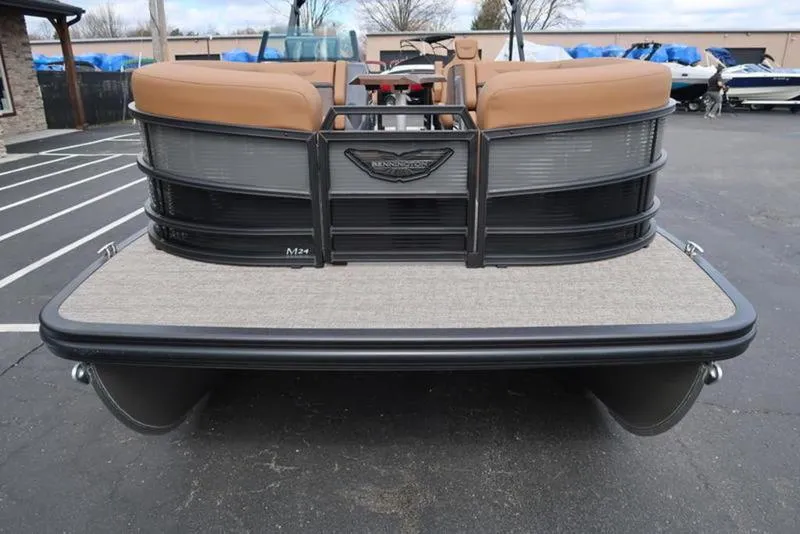 Slide: The Image of 2025 Bennington M Quad Bench 24 MFB pontoon boat, rear view, in a parking lot. - 3
