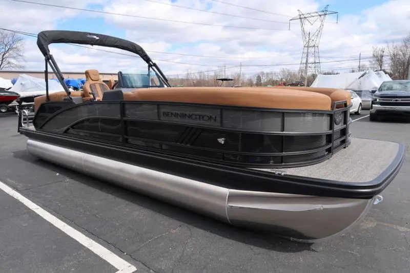 Slide: The Image of 2025 Bennington M Quad Bench 24 MFB pontoon boat in a parking lot. - 5