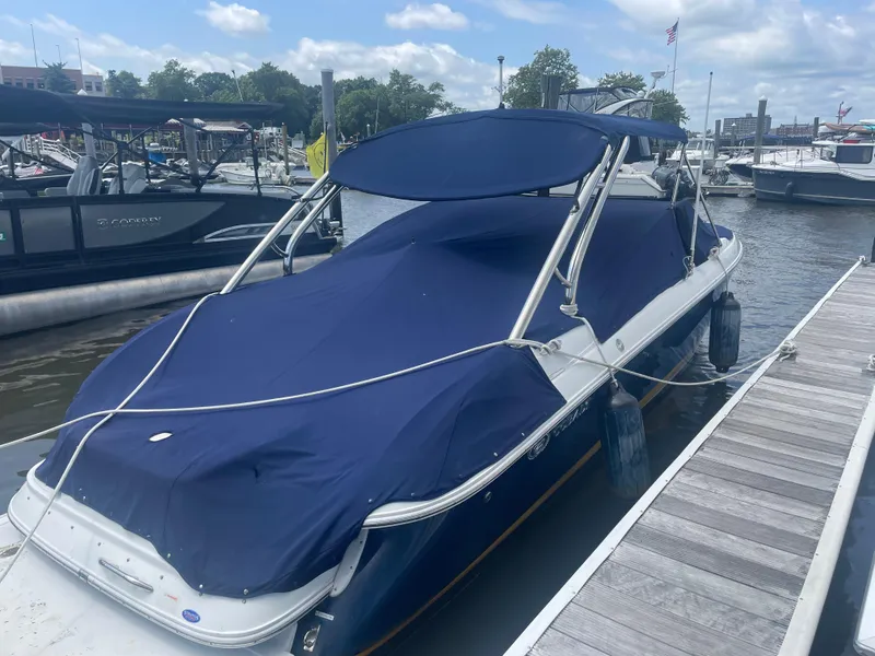Slide: The Image of 2008 Cobalt 272 boat docked, covered with a blue tarp, in a marina setting. - 14