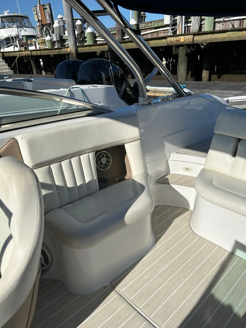 Slide: The Image of 2008 Cobalt 272 boat interior with white seating and sleek design at a marina. - 5