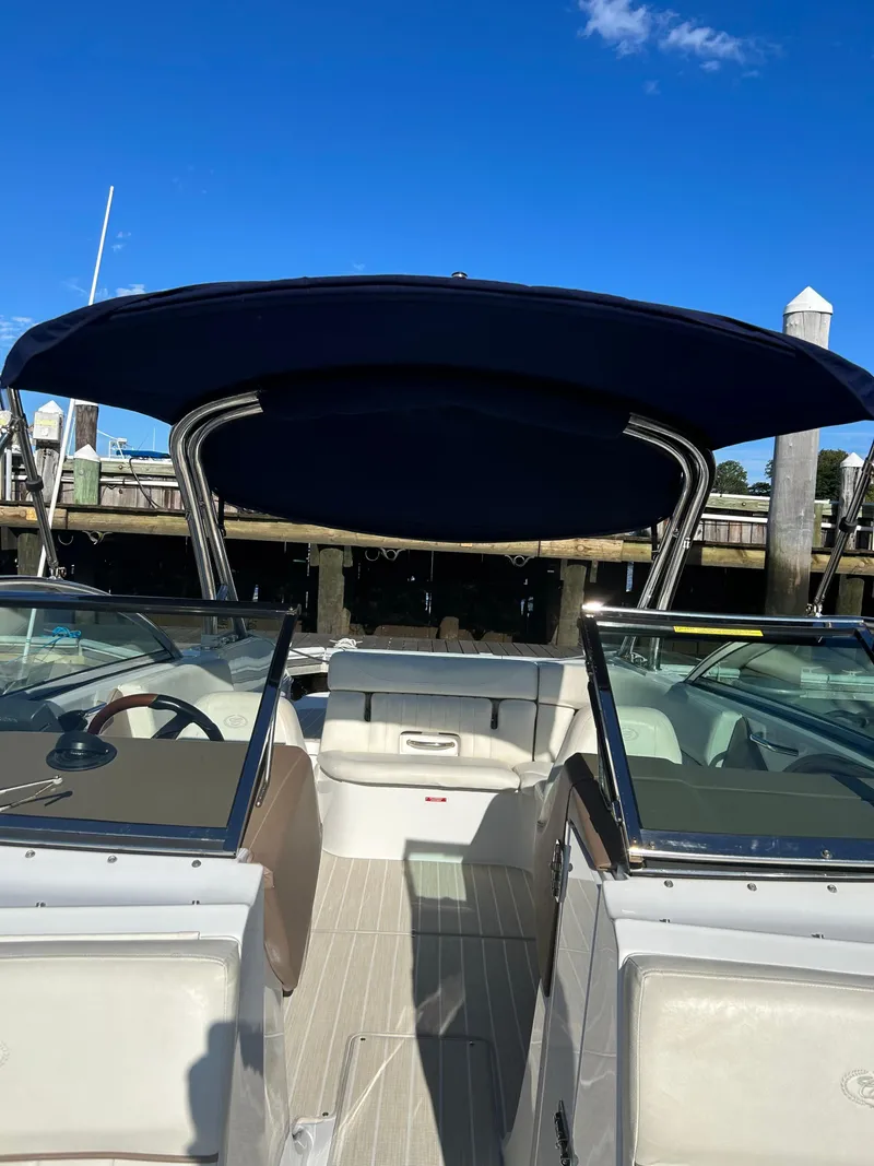 Slide: The Image of 2008 Cobalt 272 boat interior with blue canopy, docked under clear sky. - 9