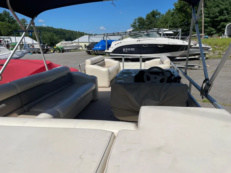 Slide: The Image of 1999 Harris Sunliner 240 pontoon boat with spacious seating, parked outdoors under clear skies. - 7